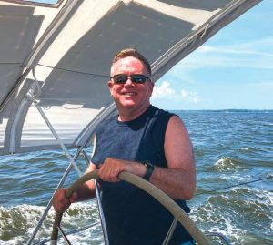 The author’s husband atthe helm during a spirited
daysail to their next
destination.