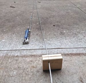 Laying out the rigging wire in thedriveway before measuring and cutting.
Lee and Traci made a jig from a piece of
scrap wood to help cleanly cut the wires.