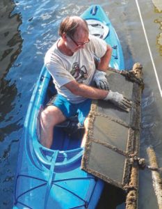 Drew Frye cleans a four-panel paint testing board.