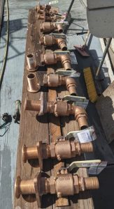 The lineup of fresh through-hullassemblies and backing plates ready
for install.