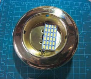 a single LED array sits inside the brass housing for one of the boat’s cabin lights.