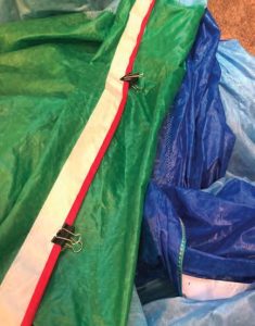 John used clips to hold the leech edge tape in place before putting it back on the newly sewn edge.