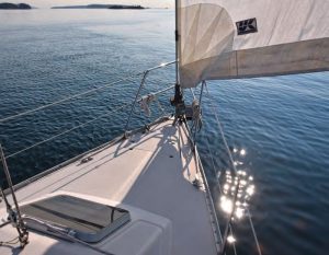 The bow is clean, with ground tackle stowed in a locker and cleats mounted quite far aft and near the rails.