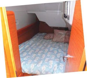 A closer look inside the quarter cabinwith its one portlight opening into the
cockpit footwell. There is floor space to sit
and close the door.