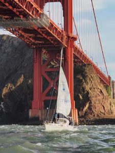 Scott raises Azimuth's mainsailas they're swept under the Golden Gate
Bridge on a 5-knot ebb.