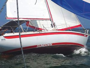Sundown sails hard over in 2012, showingthe original boot stripe graphic.