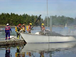 Firefighters douse a fire that engulfed a small sailboat at the dock. The damage was catastrophic