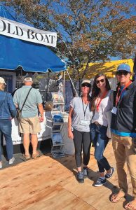 Senior Editor Wendy MitmanClarke (far left) greets Marissa and Chris Neely of S/V Avocet, who stopped by the Good Old Boat booth during the U.S. Sailboat Show in 2021.