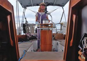 Kirra at the helm of La Senda, a 1983Cape Dory 31.