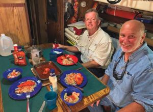 Erie Canal delivery crew Jim McGinnis(left) and Mike Crouse (right) get ready
to tuck into a home-cooked dinner while
underway.