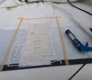 The perimeter of the newpatch is outlined in tape,
while adhesive has been
applied to the area to
be patched. Patch size is
determined by whether
the tear is low-load or
high-load