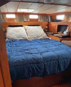 The queen-size berth inthe aft cabin has 6-foot
3-inch headroom and
is flanked by bedside
counters and storage.