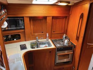 The L-shaped galley features a doublesink, gimballed stove/oven, a microwave,
icebox with refrigeration, and good
storage