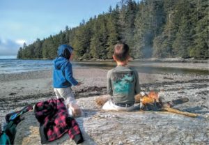 boys sitting in front of campfire