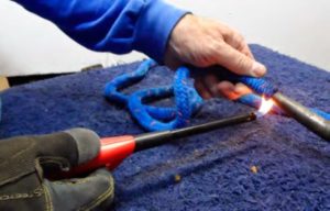 man melting end of rope with lighter