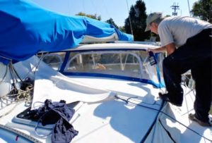 man cleaning boat dodger