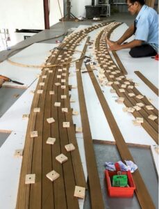 man working with teak strips