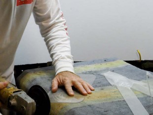 man using a grinder on plastic storm window