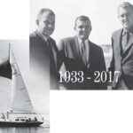 a group of men and a sailboat at sea