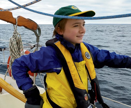 boy steering a sailboat
