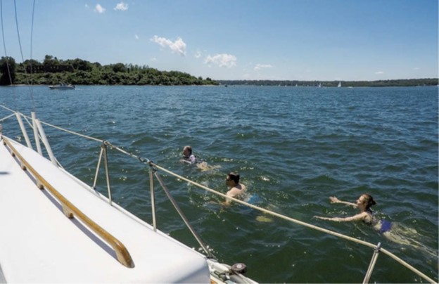 people swimming next to boat