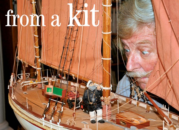 man looking over boat model