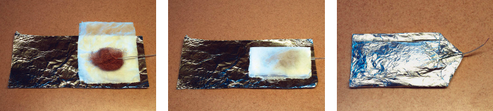 Greater surface area of the same metals can create a more powerful cell. Strip a strand of copper wire and insert one end in a ball of bronze wool, at left. Completely enclose these items in a paper towel that has been soaked in a solution of salt and vinegar, center, and set them on the aluminum foil. Fold the aluminum foil over and pinch the edges together to seal and complete the cell, at right.