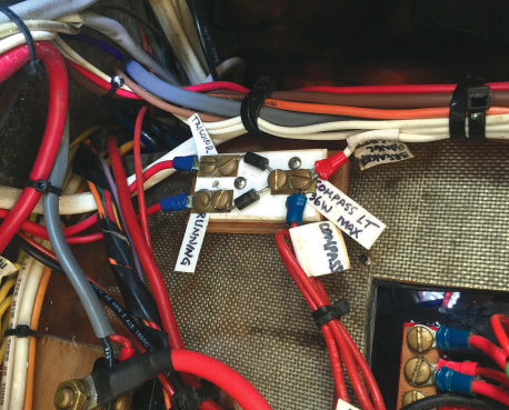 Under sail, John uses the masthead tricolor running light, but when motoring he must use the deck-level lights. The compass light is wired into both circuits so it turns on with either.