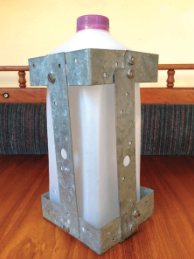 Milk is kept cold and accessible in this metal cage fashioned from galvanized tie straps and stainless-steel screws and nuts.