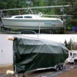 Unsupported inside the dark tarp oven, at left, the furler extrusion had warped. Now stored inside its stiff storage tube, it lays along the deck of Someday Lady, top of page.