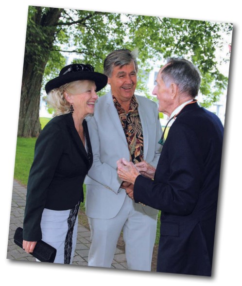 David Howard, at right, welcomes Martin Klacko and his wife, Bette Pender, to the garden party he organized at RCYC.