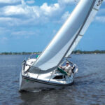 Kim Hogan shows off the sharp lines and sparkling flat-water performance of Willow, his Precision 23, on the St. Lucie River on Florida’s east coast, top of page.