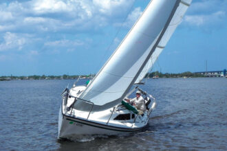Kim Hogan shows off the sharp lines and sparkling flat-water performance of Willow, his Precision 23, on the St. Lucie River on Florida’s east coast, top of page.