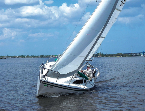 Kim Hogan shows off the sharp lines and sparkling flat-water performance of Willow, his Precision 23, on the St. Lucie River on Florida’s east coast, top of page.