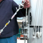 Showing off a device made of pipe cleaners to clean the mainsail slot