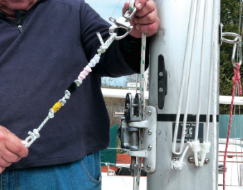 Showing off a device made of pipe cleaners to clean the mainsail slot