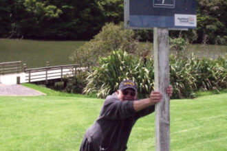 Picture of someone leaning on a slippery slope sign