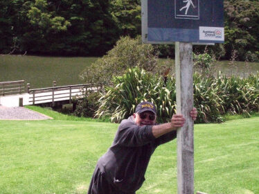 Picture of someone leaning on a slippery slope sign