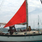 For reaching and downwind courses or for heaving-to, Ed and Ellen sheet the trysail off centerline using one sheet for each tack, top of page. The sheets must be long enough to cross over the boom. Lazy-jacks, if fitted, would require them to be longer.