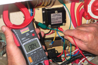 David measures voltage with a multimeter, top of page. The one he’s using has a current clamp that allows him to measure current without disconnecting wires.