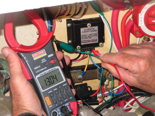 David measures voltage with a multimeter, top of page. The one he’s using has a current clamp that allows him to measure current without disconnecting wires.