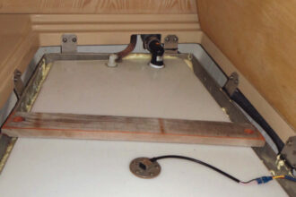 When the leaking aluminum water tank rebuffed Alan’s attempts to remove it, he placed a new polypropylene tank inside it.