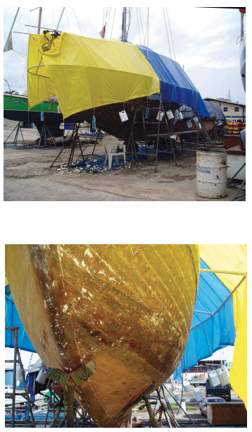 The water jugs weighing down Shirley’s tarp look a bit makeshift, above, but they did their job when the wind blew. The extension created enough room for her to work on the entire hull, below.