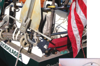 On small boats, storage space is at a premium, but with a little creativity you can still find a spot for a stern anchor, above. This lightweight Fortress has good holding power and is stored in a bracket mounted to the stern pulpit and just above the rolled-up rope-and-wood swim ladder. Stern rollers are mounted at the port and starboard rail corners, for use in anchoring, warping, docking, or when towing a drogue to slow down in heavy weather at sea. A 200-foot stern anchor rode is stored in a locker just aft of the tiller, at right. Jim cut the hole, epoxied the hook under the screw-on lid, and built a bulkhead underneath to contain the rode. This was previously unused space.