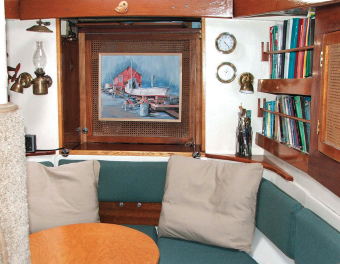 The bookshelves and lockers on the starboard side of the main (forward) cabin were once half of a bunk board. The oval table replaced a drop-leaf variety. The carpet-wrapped mast support is a really good scratching post for the ship’s cat.