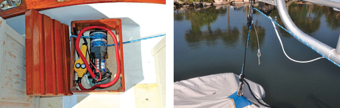 Roger built a teak box to contain the winch and the control unit to protect them from the elements, at left. It is sturdy enough to use as a step. Wire strops clip onto the davit and dinghy to provide extra support, at right. The black strop lowers the stern so the boat will drain.