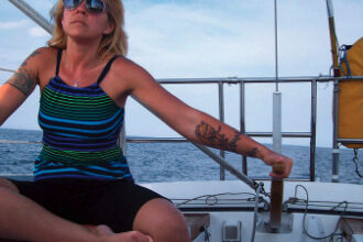 Once she discovered sailing, Lisa, here at the helm of Escape, found it brought back fond memories of time spent on the water with her father.