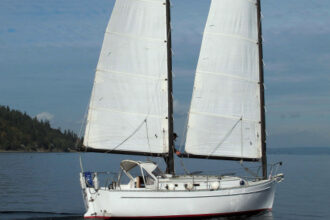 Tom Curley tends lines on the cabintop of his Freedom 28, Catnip, as she sails herself under her cat ketch rig, a trait that makes her very adaptable to singlehanded sailing.