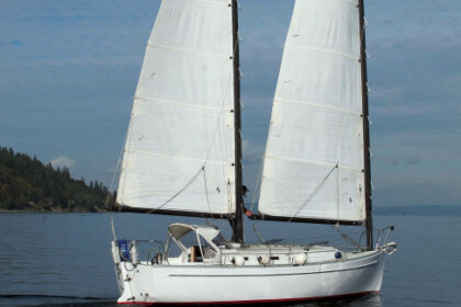 Tom Curley tends lines on the cabintop of his Freedom 28, Catnip, as she sails herself under her cat ketch rig, a trait that makes her very adaptable to singlehanded sailing.