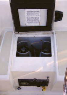 Two 11-pound propane tanks are neatly stowed in a dedicated cockpit locker that drains overboard. The engine control panel is recessed into the seat front.